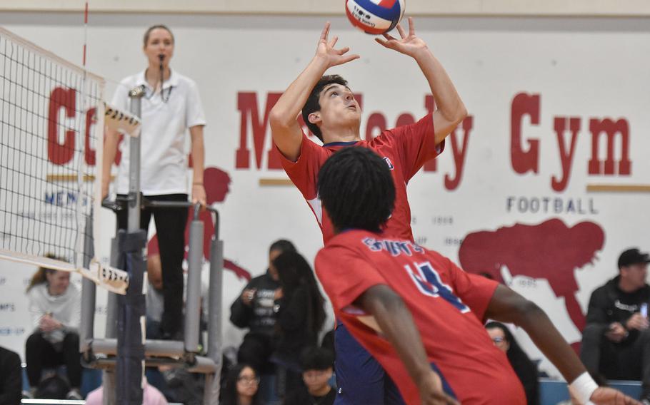 Aviano's Cristiano Peterson sets the ball as teammate Jules Lasalle-Bryant approaches the net Saturday, Oct. 5, 2024, during a match against Sigonella at Aviano Air Base, Italy.