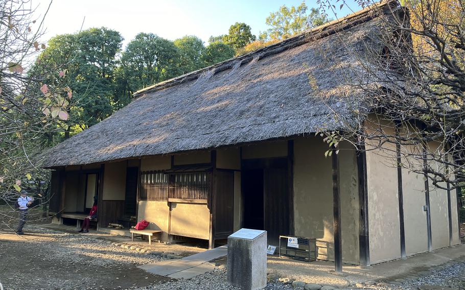 A cottage with a thatched roof stands apart.