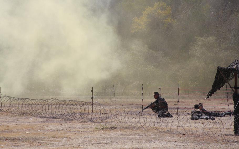 Smoke grenades cloud a mock United Nations humanitarian relief distribution station