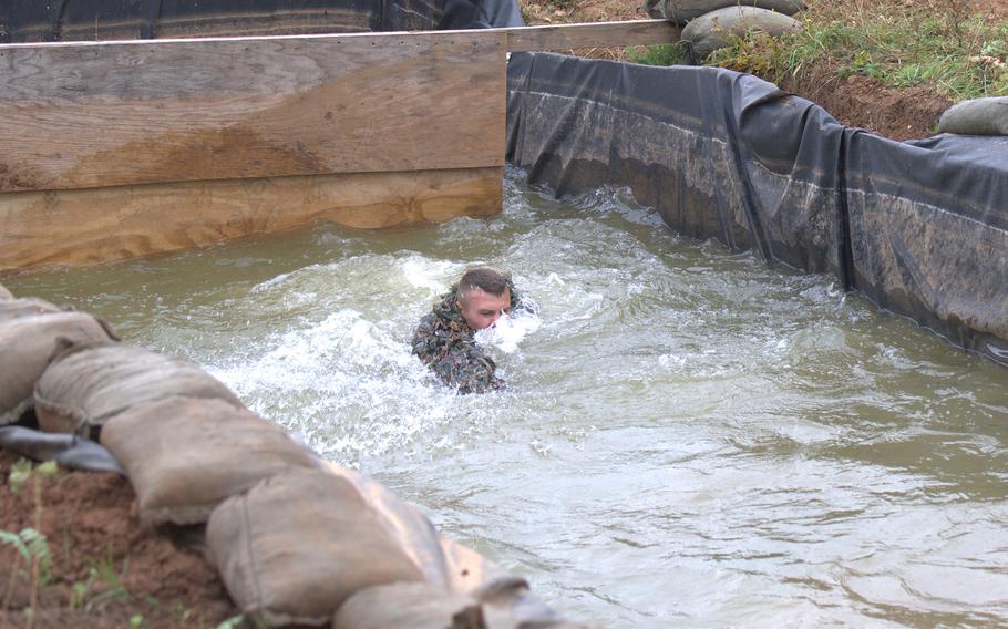 A French sniper swims through a flooded trench during the eighth annual European Best Sniper Team Competition on Aug. 8, 2024, at the Joint Multinational Readiness Center in Hohenfels, Germany.