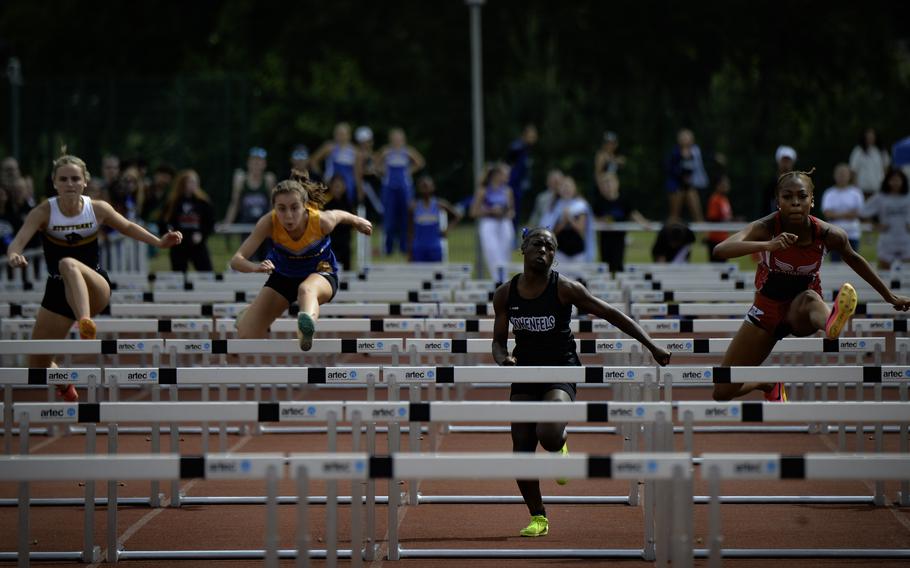From right, Lellah Guhn of Kaiserslautern leaps over a hurdle to win the girls 100 meter hurdles at the 2024 DODEA European Championships at Kaiserslautern High School in Kaiserslautern, Germany, on May 24, 2024, while Kenya Tucker of Hohenfels follows closely. Angelica Shea of Wiesbaden and Isabella Segalla of Stuttgart are also pictured. Guhn and Tucker set personal records with times of 15.38 and 16.28 seconds, respectively.