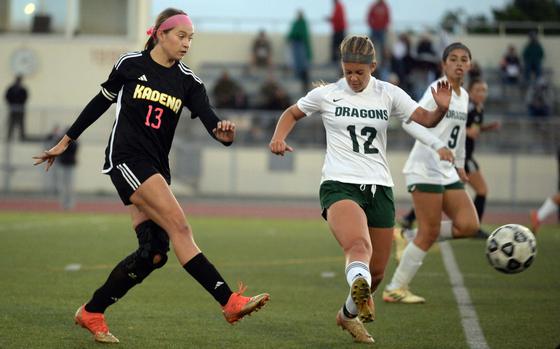 Kadena's Sydney Pontious boots the ball past Kubasaki's Aubrey Rancloes.