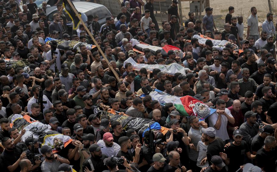 Mourners carry the bodies of Palestinian men who were killed during an Israeli military operation, some draped in the Palestinian and the Islamic Jihad militant group flags, during their funeral in Jenin, West Bank.