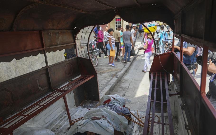 The body of a man killed in Haiti is tied down in a bus.