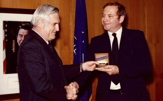 This photograph released by the CIA on behalf of the family of former CIA officer Edward B. Johnson shows Johnson, right, receiving the CIA's Intelligence Star from John N. McMahon, then the agency's deputy director for operations, in May 1980. Edward B. Johnson, who as a Central Intelligence Agency officer traveled into Iran with a colleague to rescue six American diplomats who fled the 1979 U.S. Embassy takeover in Tehran, has died, the CIA confirmed on Monday, Sept. 9, 2024. He was 81. (Family of Edward B. Johnson/CIA via AP)