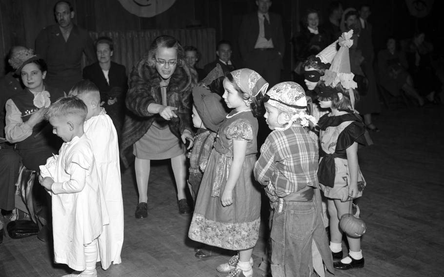 Two ghosts, a milk maid, and a pirate get in line with other costumed children for the Halloween parade. 