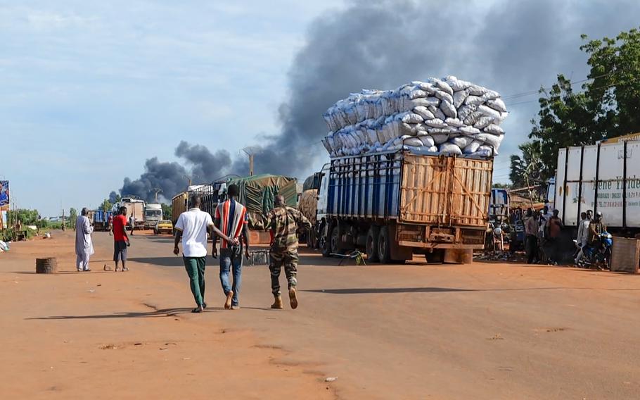 Malian security personnel detaining a man