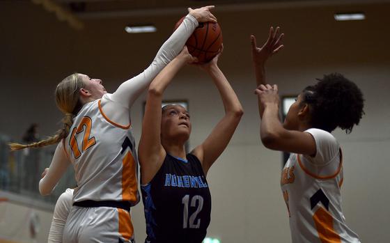 Hohenfels' Angelaurie Owens comes down with a rebound against Spangdahlem's Kylie McVey, left, and Brooklyn Shakir-Bacchus during a Jan. 31, 2025, game at Spangdahlem High School in Spangdahlem, Germany.