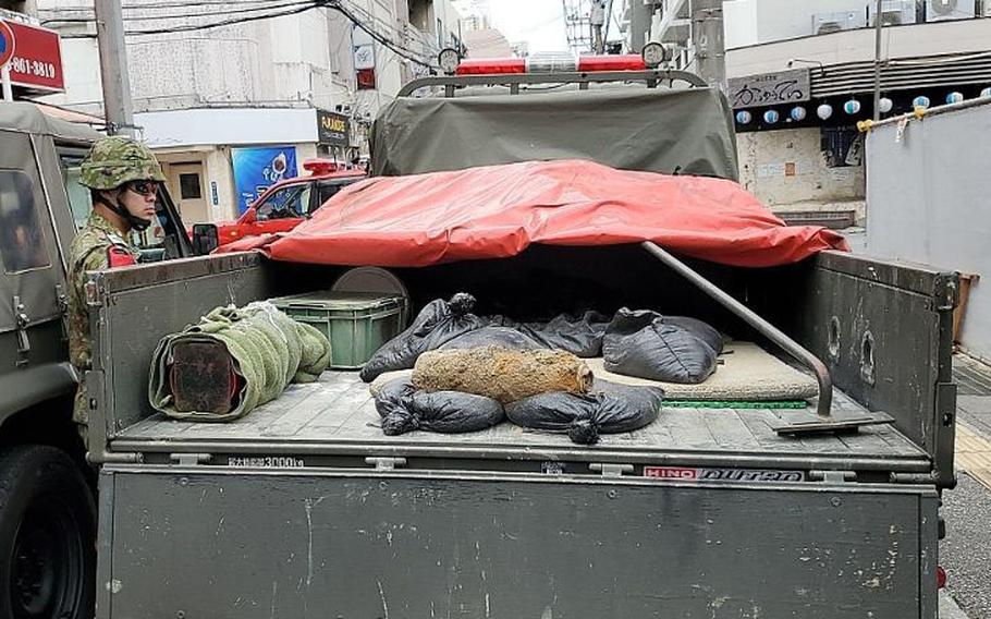 A defused U.S.-made, World War II-era shell sits on a truck at a construction site.