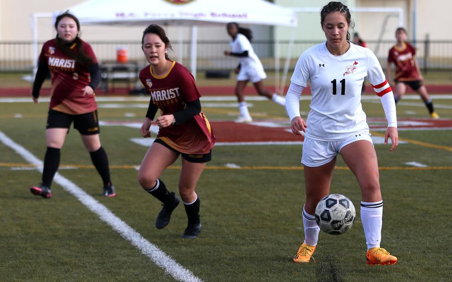 E.J. King’s Maliwan Schinker plays the ball off the turf against Marist Brothers  during Friday’s Western Japan Athletic Association girls soccer tournament. The Cobras won 3-2. Schinker kicked the winning goal in last year’s tournament to help the Cobras capture the title.