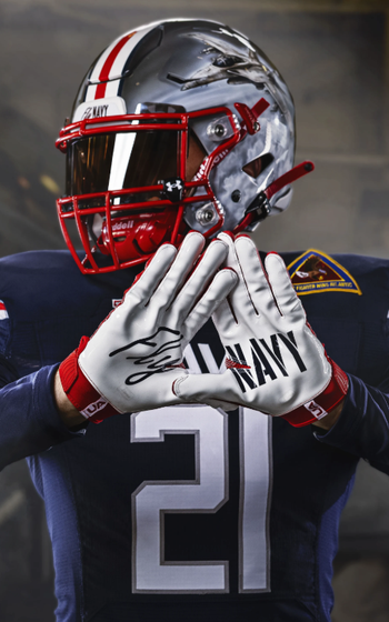 A Navy player holds up his hands, and Fly Navy is printed on his gloves.