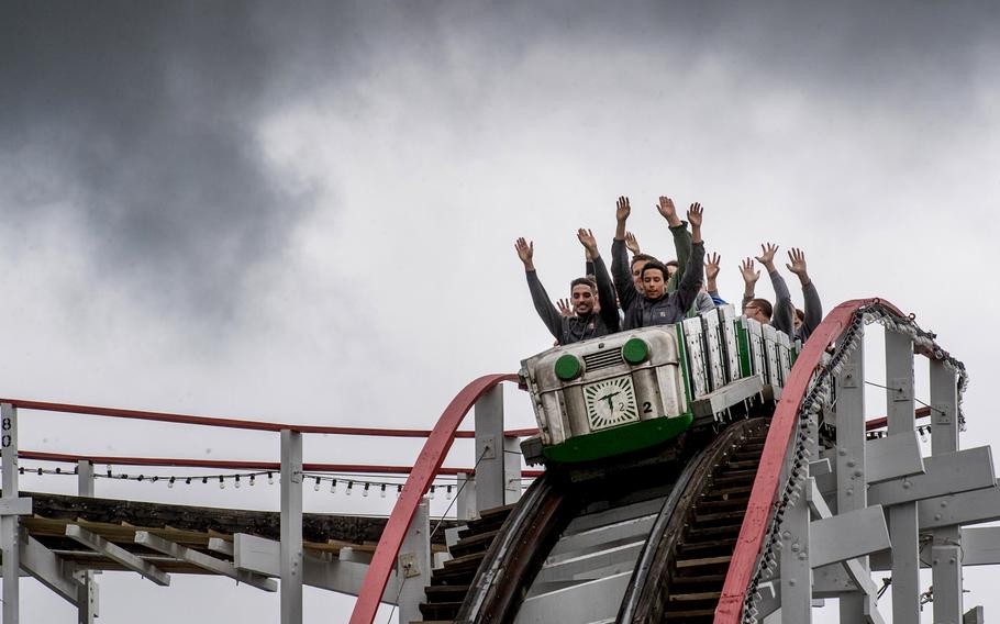 Guests ride the Thunderbolt under a menacing sky on April 22, 2023, at Kennywood Park in West Mifflin, Pa. This year the wooden roller coaster celebrates its 100th year. 