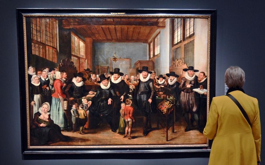 A visitor takes a closer look at “The registration of paupers and orphans at the Aalmoezeniershuis,” by an unknown artist. The work, possibly painted by David Vinckboons in 1626, is on display in the exhibit “Rembrandt’s Amsterdam. Golden Times?” at the Städel in Frankfurt.