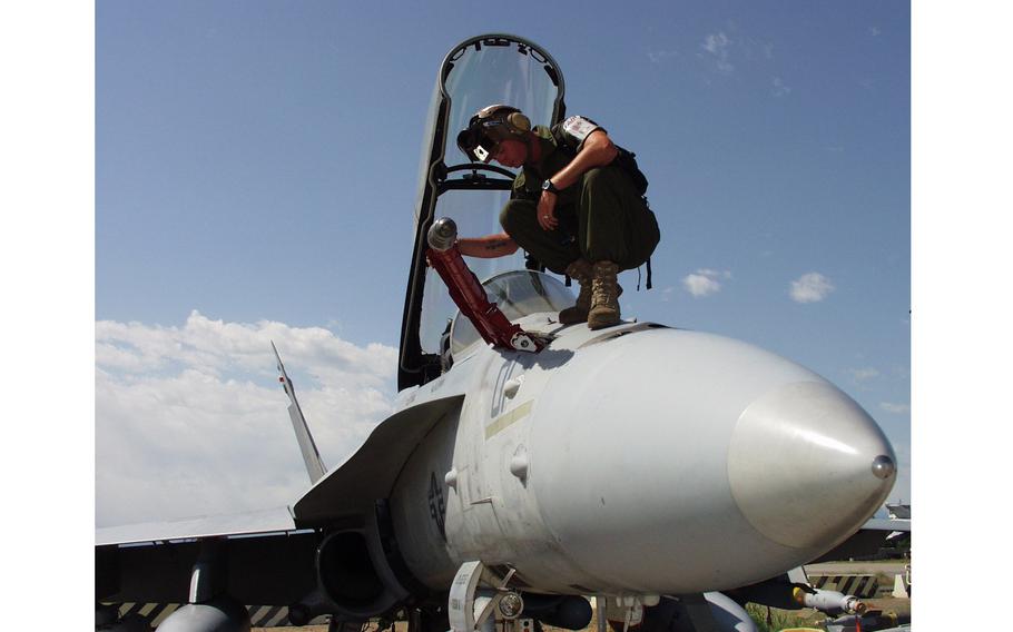 A Marine checking the refueling cone on an F/A-18D Hornet