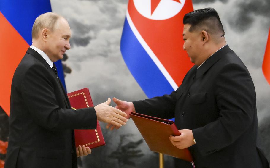 Russian President Vladimir Putin and North Korean leader Kim Jong Un exchange documents during a signing ceremony of the new partnership in Pyongyang on June 19, 2024.