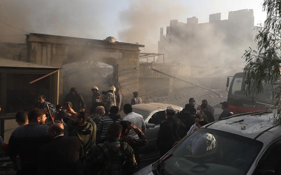 Security officers and rescuers gather at a destroyed building hit in an Israeli airstrike in Damascus, Syria, Thursday, Nov. 14, 2024. (AP Photo/Omar Sanadiki)