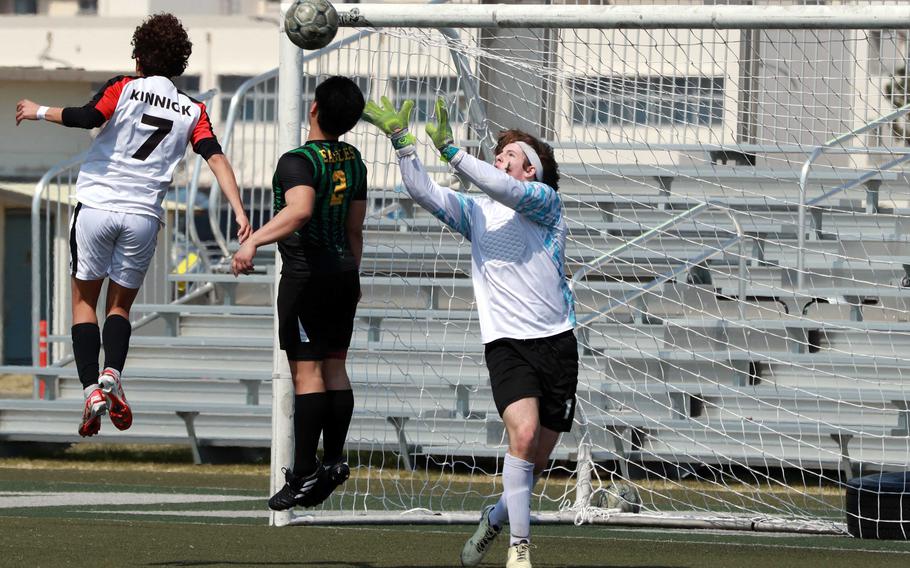 Nile C. Kinnick's Franco Villota heads the ball in front of Edgren's Brayden Reyes and keeper Cole Donnelly during Saturday's DODEA-Japan boys soccer match. The Red Devils won 10-0.