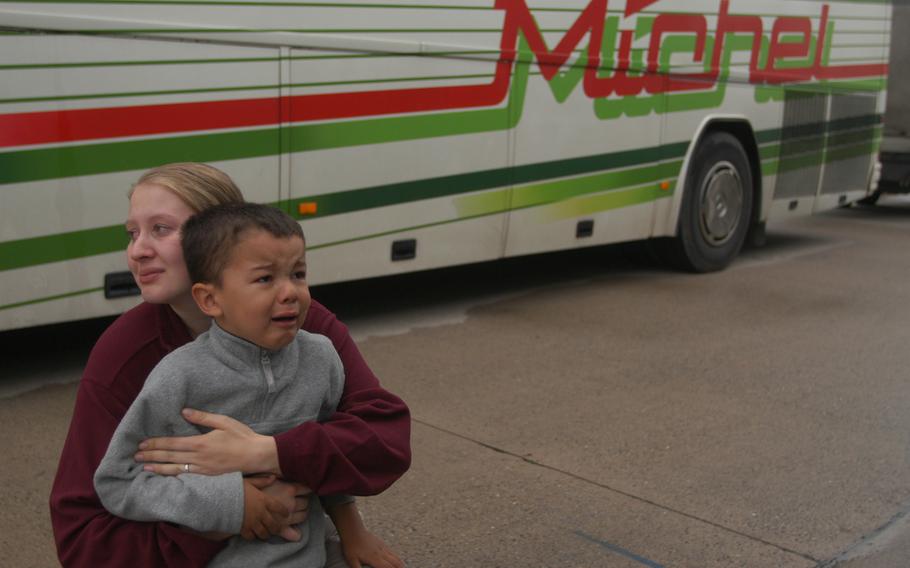 Natalie Hepting holds onto her son, Jordan, 3, as the toddler watches his father, Sgt. Robert Woodring, board a bus on his way to a one-year deployment to Iraq. Woodring is one of more than 200 596th Maintenance Company soldiers who said goodbye to friends and family before leaving Monday. Hepting is pregnant, and expects to give birth in January, she said. 