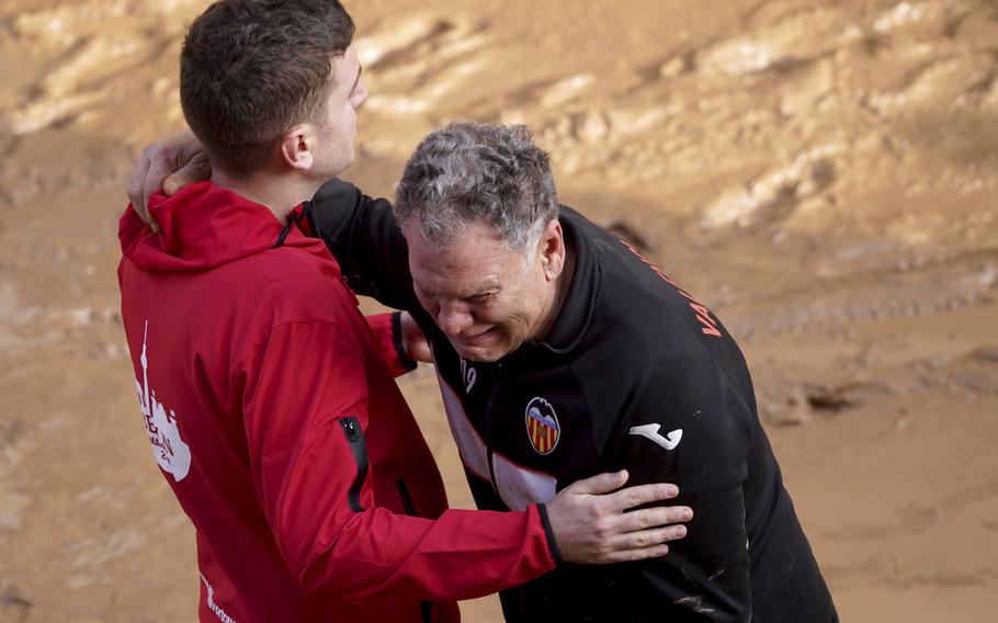 A man weeps as he waits for news of his relatives trapped during the floods in Spain.