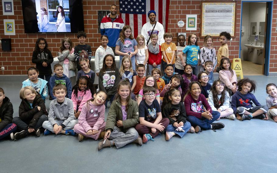 Former New York Giants football players Brandon London and Victor Cruz pose for a photo with a Vilseck Elementary School class during a visit to the U.S. Army base at Vilseck on Thursday. 