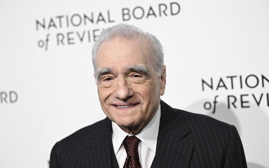 Martin Scorsese, in a pinstriped black suit jacket, white shirt and red diamond-patterned tie, smiles while posing for photos at the National Board of Review awards gala in New York on Jan. 11, 2024. 