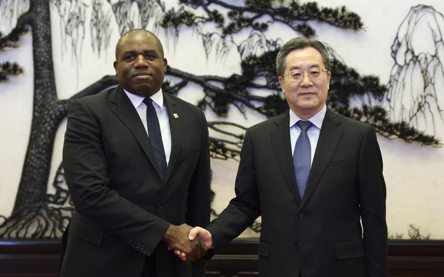 Britain’s Foreign Secretary David Lammy and Chinese Vice Premier Ding Xuexiang shake hands before their meeting at the Great Hall of the People in Beijing, China, Friday, Oct. 18, 2024. 