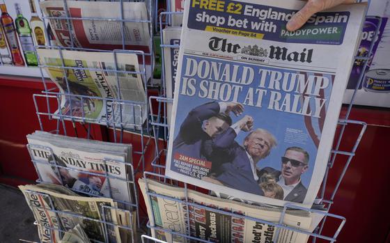 A woman buys a copy of the British Mail on Sunday newspaper at a newsagents in London, Sunday, July 14, 2024, showing the reaction to events at former President Trump's campaign rally in Butler, Pennsylvania. Donald Trump's campaign says he is "fine" after what law enforcement officials are treating as an assassination attempt during a rally in Butler, Pennsylvania. (AP Photo/Kirsty Wigglesworth)