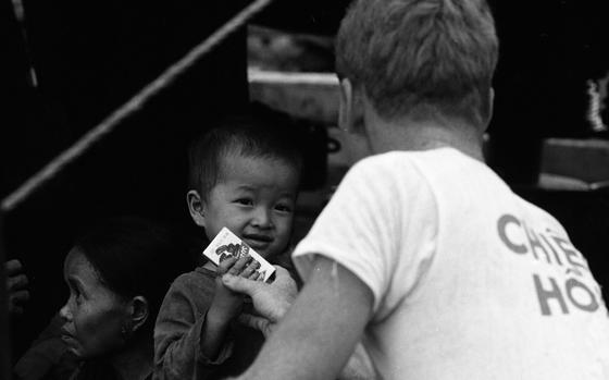 Saigon, South Vietnam, October 1969: Unidentified person hands out boxes of Jujyfruits candy to local Vietnamese children in Saigon. 

This photo was one of many taken during Stars and Stripes photographer Joe Kalamick's multi-day assignment in Saigon where he covered a press conference, photographed men taking measurements outside of the U.S. embassy, and the inside of a transport plane's cockpit. No caption information survived for any of the images and none of the images taken were published, so archives staff have little to go on. 

Most negatives and photo prints in the Stars and Stripes archives have at least the minimal information of a photographer name and title, but even if more is found, archives staff often spend hours researching and adding information to the images before they are saved in their final digital format and can be found in the future through keyword searches in the paper's in-house digital archive.

Looking for Stars and Stripes’ coverage of the Vietnam War? Subscribe to Stars and Stripes’ historic newspaper archive! We have digitized our 1948-1999 European and Pacific editions, as well as several of our WWII editions and made them available online through https://starsandstripes.newspaperarchive.com/

META TAGS: South Vietnam; Vietnam War; child; Vietnamese; Archives Month; 