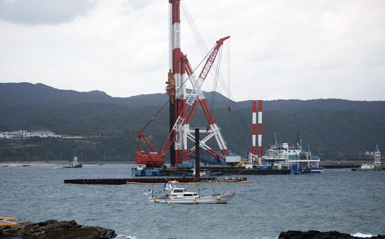 A construction vessel floats on a bay.