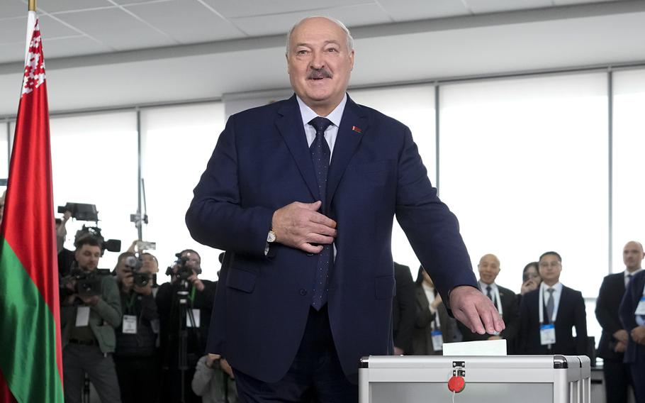 The Belarusian president casts his ballot into a ballot box.