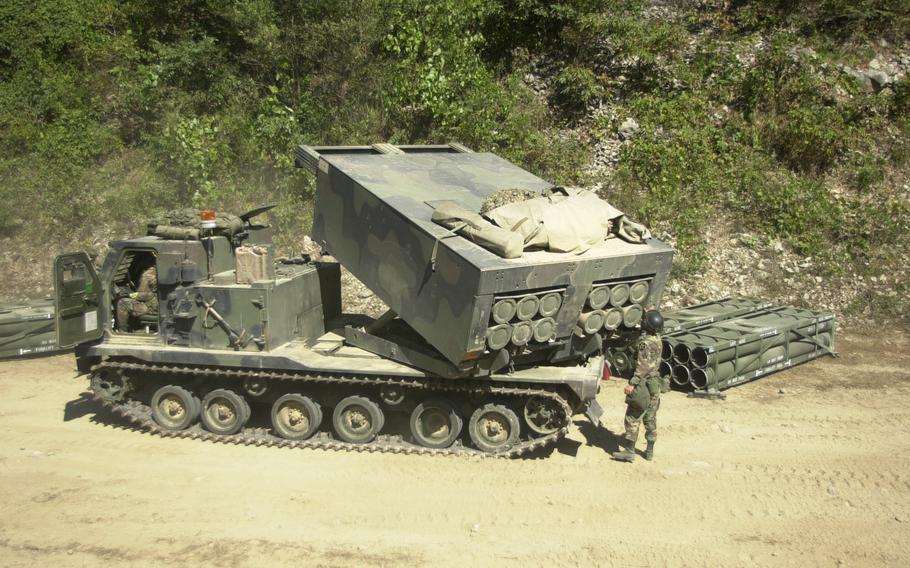 A soldier watches as the (MLRS) multiple launch rocket system vehicle rotates the rocket pod bay