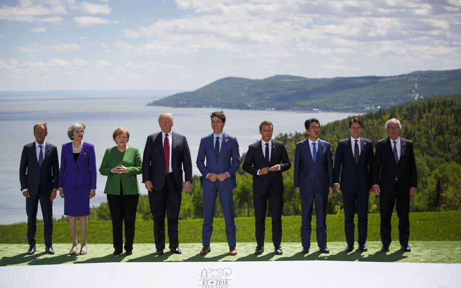 Then-European Council President Donald Tusk, then-UK Prime Minister Theresa May, Merkel, then-US President Donald Trump, Trudeau, Macron, then-Japanese President Shinzo Abe, then-Italian Prime Minister Giuseppe Conte and then-European Commission President Jean-Claude Juncker at the family photo for the G-7 summit in Canada in June 2018. 