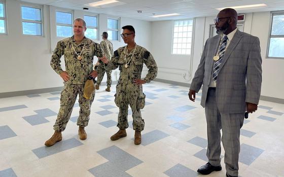 The commander of Naval Base Guam, Capt. John Fry, left, and other officials tour a new annex for William C. McCool Elementary Middle School, Dec. 12, 2024.