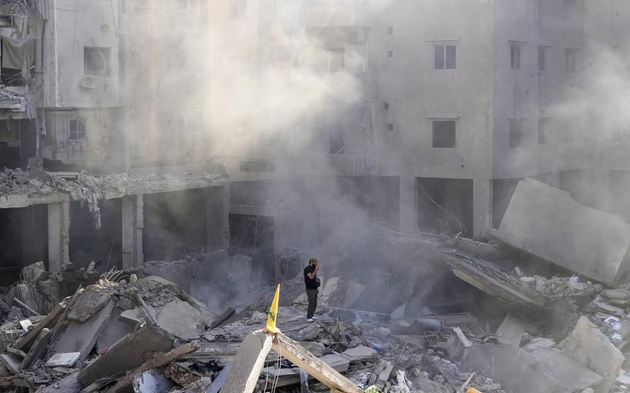 A man stands on the rubble of buildings in Beirut’s southern suburbs.