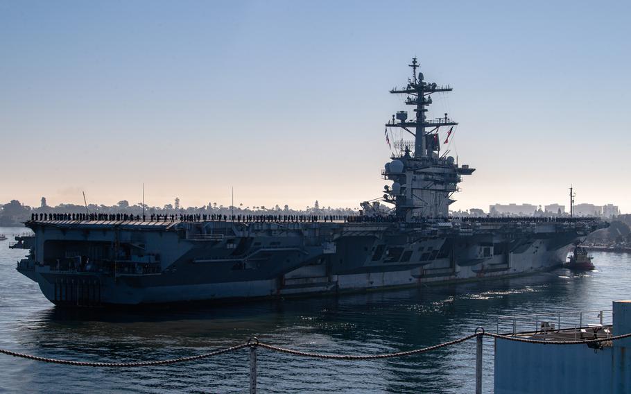 Sailors and Marines man the rails of the USS Abraham Lincoln