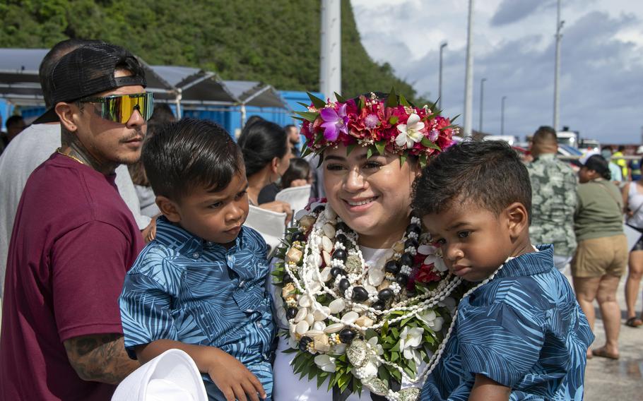 Petty Officer 1st Class Aubriaunne DuPont, a logistics specialist aboard the aircraft carrier USS Abraham Lincoln, poses with family and friends on a pier at Naval Base Guam, Sunday, Aug. 4, 2024.