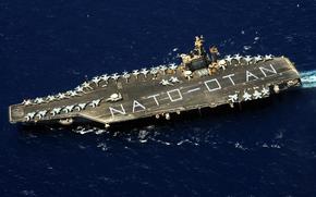 Sailors form on the flight deck of the aircraft carrier USS Dwight D. Eisenhower to spell out NATO-OTAN in the Mediterranean Sea in 2009. The direction of the alliance will be the subject of debate as President Joe Biden welcomes NATO and allied leaders to a 75th anniversary summit in Washington, D.C., beginning Tuesday.