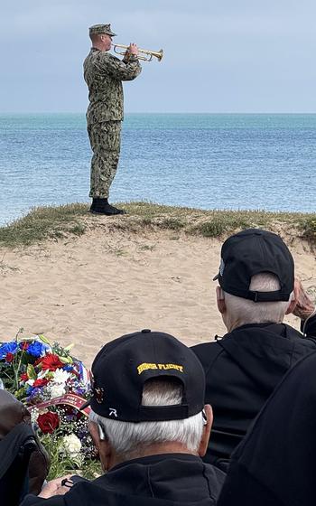 A bugler stands on a sandy bluff and plays taps at Omaha Beach on June 4, 2024, during a visit by a group of nearly 70 World War II veterans flown to France for the 80th anniversary of the D-Day landings.