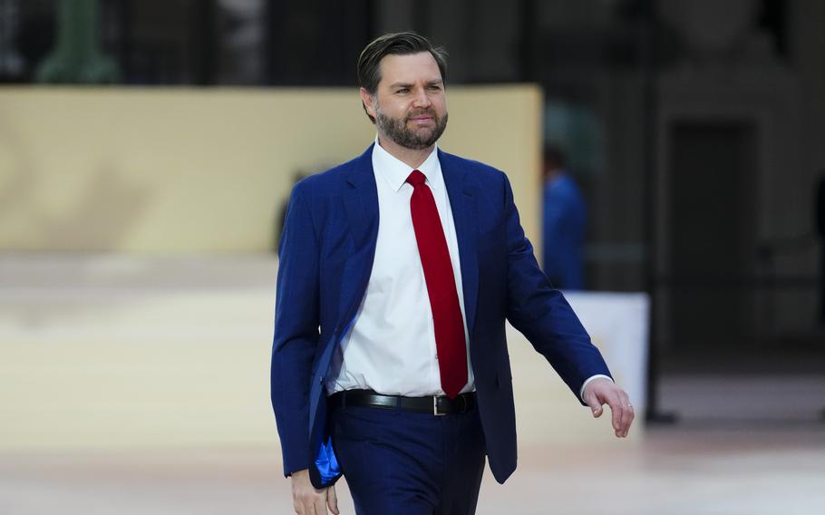 United States Vice President JD Vance walks wearing a blue suit.