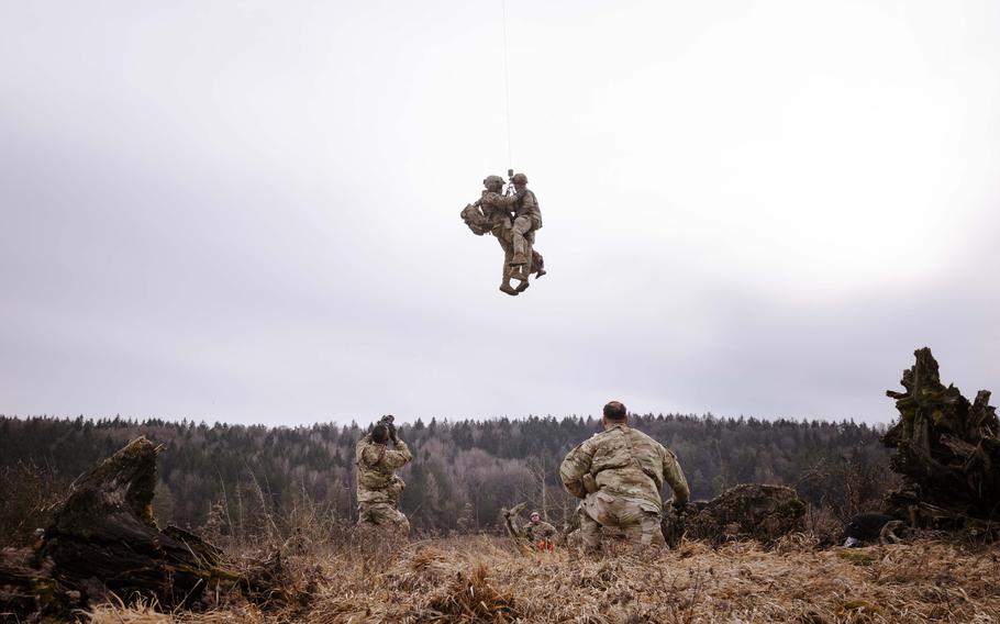 U.S. soldiers are lifted via a tether.