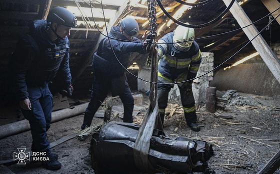 The Ukrainian Emergency Service cleans up after a Russian missile strike in Kyiv.