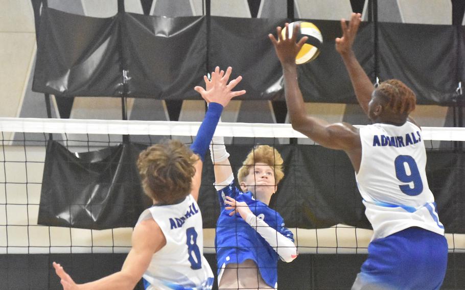 Sigonella’s Cooper Harrison tries to hit through the Rota block of Tyler DeMeritt and Brian Lieba during the opening day of the DODEA-Europe boys volleyball championships in Vicenza, Italy.