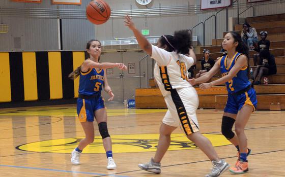 Yokota's Erica Haas passes against Kadena's Tianna Crawley as Yokota teammate Arianna Obiacoro moves in to help.