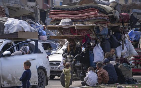 Displaced Palestinians with their belongings gather near a roadblock on Salah al-Din Street, as they wait to return to their homes in the northern part of the Gaza Strip, Sunday, Jan. 26, 2025, days after the ceasefire deal between Israel and Hamas came into effect. (AP Photo/Abdel Kareem Hana)