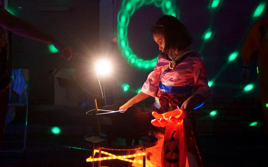 A trick-or-treater takes some Halloween candy at Yokosuka Naval Base, Japan, Oct. 31, 2024.