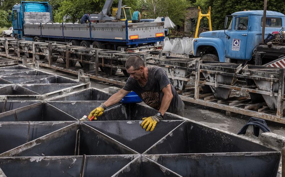 A prisoner works on making “dragon’s teeth” — pyramid blocks meant to foil tanks — at a prison colony in Ukraine. 