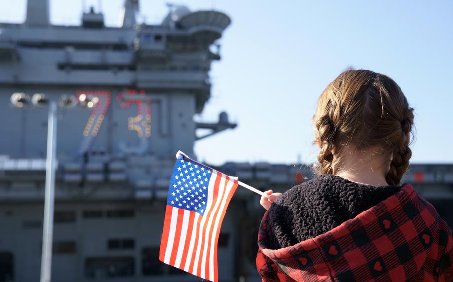 Family members and friends cheer pierside as the aircraft carrier USS George Washington arrives at Yokosuka Naval Base, Japan. Nov. 22, 2024.