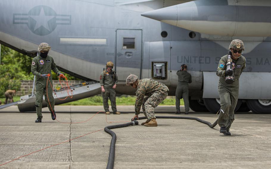 U.S. Marines with Marine Wing Support Squadron 371 and Philippine sailors run a fuel line after refueling a KC-130J Super Hercules at Laoag International Airport, Philippines, June 15, 2024. 