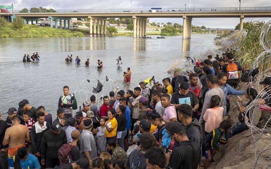 Asylum seekers wait to be processed by U.S. Border Patrol agents after crossing the Rio Grande from Mexico into the United States on Sept. 30, 2023, in Eagle Pass, Texas.