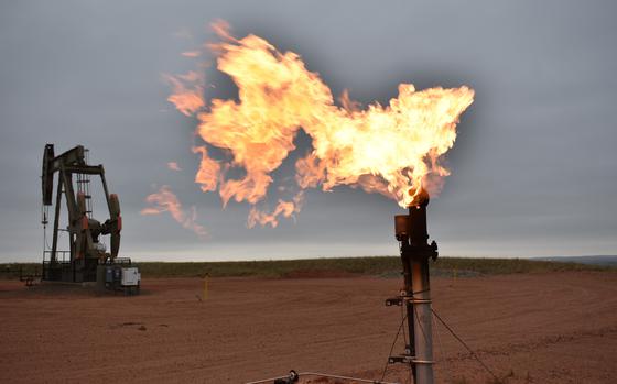 FILE - A flare burns natural gas at an oil well in Watford City, N.D., Aug. 26, 2021. (AP Photo/Matthew Brown, File)